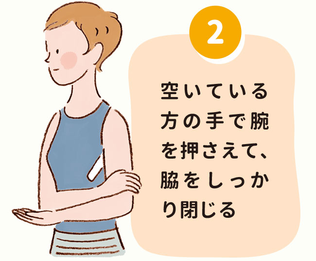 2.空いている方の手で腕を押さえて、脇をしっかり閉じる